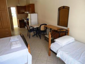 a room with two beds and a table and a kitchen at Alykes Studio Rental in Alykes
