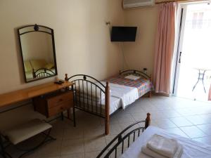 a bedroom with a bed and a desk and a mirror at Alykes Studio Rental in Alykes