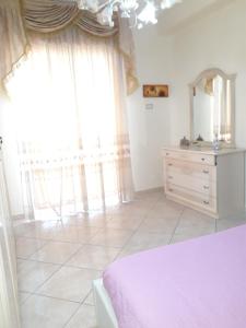 a bedroom with a bed and a dresser with a mirror at Casa Imma Napoli in Naples