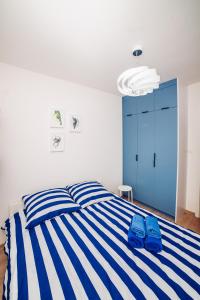 コウォブジェクにあるApartament Blue Point 102 PREMIUMのベッドルーム1室(青と白のストライプのベッド、青の靴付)