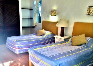 duas camas num quarto com um candeeiro sobre uma mesa em Hermoso departamento a una cuadra de la playa em Puerto Vallarta