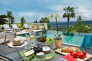 a table with a tray of food on it next to a pool at Luxury Pool Apartment at Villa Seburga in Saint-Paul-de-Vence