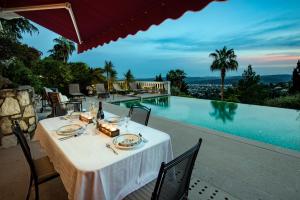 a dining table on a patio next to a swimming pool at Luxury Pool Apartment at Villa Seburga in Saint Paul de Vence