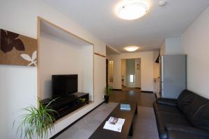 a living room with a couch and a flat screen tv at Yukon in Kutchan