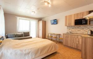 a bedroom with a bed and a kitchen with a table at Rinvasta in Druskininkai