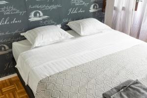 uma cama com lençóis brancos e almofadas num quarto em Mikkeli Citycenter apartment with sauna em Mikkeli