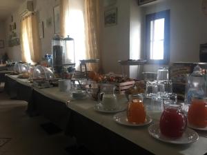 une rangée de tables avec des assiettes de nourriture et de boissons dans l'établissement Locanda Al Castello, à Peschici