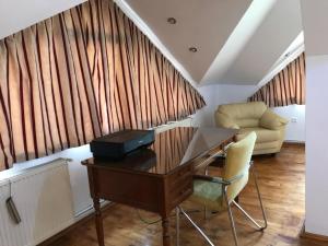 Zimmer mit einem Schreibtisch, einem Stuhl und einem Sofa in der Unterkunft Villa Bonita en Plopilor in Sibiu