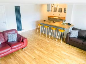 a living room with a red couch and a kitchen at Apartment 42a by the River in Inverness