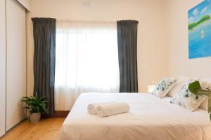 una camera da letto con un letto e due asciugamani di 29 Jane a Tanunda