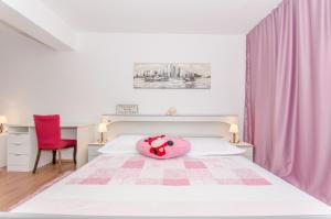 um quarto com uma almofada cor-de-rosa numa cama em Marie em Split