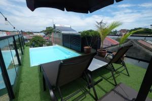 a balcony with a table and chairs and a swimming pool at 38PC Boutique Hotel in Alor Setar