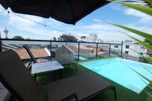 a balcony with a swimming pool and an umbrella at 38PC Boutique Hotel in Alor Setar