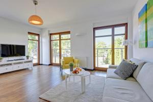 a living room with a couch and a table at Baltic Sunrise - Apartamenty przy plaży in Jelitkowo