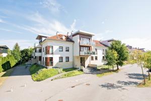 a large white house with a driveway at Baltic Sunrise - Apartamenty przy plaży in Jelitkowo