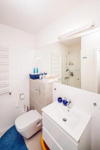 a white bathroom with a toilet and a sink at Apartament Blue Point 406 PREMIUM in Kołobrzeg