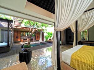 a bedroom with a bed and a swimming pool at The Amala Boutique Retreat in Seminyak