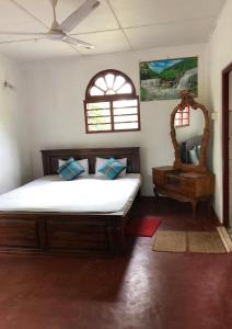 a bedroom with a large bed and a mirror at Raj Villa Kumarakanda Hikkaduwa in Hikkaduwa