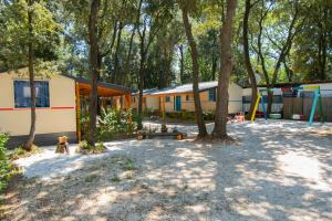 a group of buildings with trees and a playground at Mobile home - Kamp Olga in Banjole