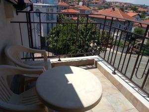 a table and chairs on a balcony with a view at Family Hotel Bellehouse in Chernomorets