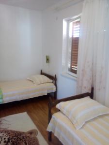 two beds in a room with a window at Apartments Draga Žaborić in Zaboric