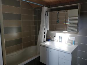 La salle de bains est pourvue d'un lavabo et d'une baignoire. dans l'établissement Chambre Chaleureuse chez l'habitant, à Bourg-en-Bresse