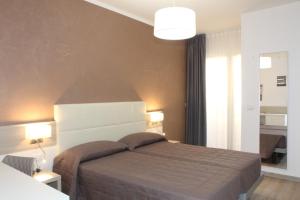 a bedroom with a bed and two lamps and a window at Hotel Garni Losanna in Bibione