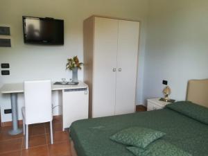 a bedroom with a bed and a desk and a television at Affittacamere Bellavista in Agropoli