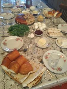 una mesa cubierta con platos de pan y bollería en Green Gables en Martuni