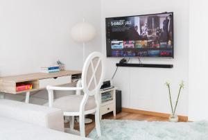 a living room with a desk and a tv on a wall at Cozy flat in the heart of the city in Oradea