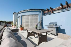 a patio with a picnic table and a grill at Jantar Apartamenty - Wylotowa in Kołobrzeg