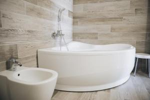 a bathroom with a white tub and a sink at Cascina Speranza Hotel in Riva presso Chieri