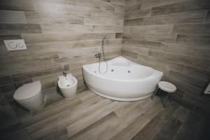 a bathroom with a white bath tub and a toilet at Cascina Speranza Hotel in Riva presso Chieri