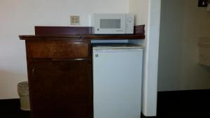 a microwave sitting on top of a counter next to a refrigerator at Texas Inn Downtown McAllen in McAllen