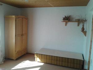 Habitación con cama y armario de madera. en Ferienwohnung "Marie", en Bansin