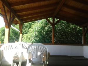 3 sillas blancas y una mesa en un porche en Ferienwohnung "Marie", en Bansin