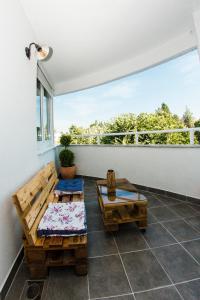 einen Balkon mit zwei Bänken und einem großen Fenster in der Unterkunft Apartment Ella in Čapljina