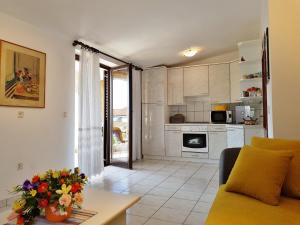 een woonkamer met een bank en een keuken bij Apartment Luna in Vodice