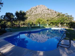 a swimming pool with a mountain in the background at Los Chozos in Benaocaz