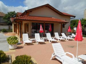a group of white chairs and umbrellas on a patio at Complex Trakite in Elkhovo