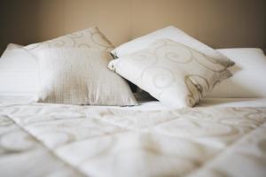 a bed with white sheets and pillows on it at Cascina Speranza Hotel in Riva presso Chieri