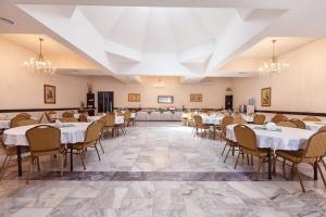 a banquet hall with tables and chairs and chandeliers at Regineh Hotel in Yerevan