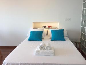 a white bed with two towels on top of it at Suite Sun And Sea in Alicante