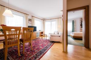 a living room with a table and chairs and a bedroom at Hotel Garni Alpenruh-Micheluzzi in Serfaus