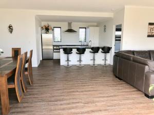 a kitchen and living room with a couch and a table at Otaki Beachfront Getaway in Otaki Beach
