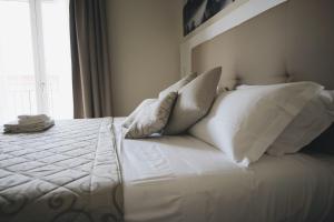 a bedroom with a bed with white pillows and a window at Cascina Speranza Hotel in Riva presso Chieri