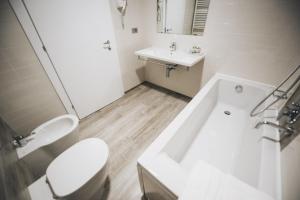 a white bathroom with a toilet and a sink at Cascina Speranza Hotel in Riva presso Chieri