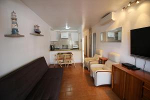 エンプリアブラバにあるBasic Comfort Apartment Pattaya 0158のリビングルーム(ソファ、テレビ付)、キッチン