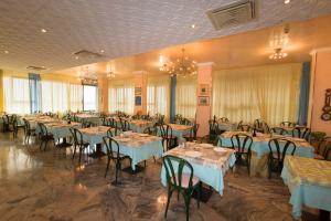 un salón de banquetes lleno de mesas y sillas en Hotel Marco Polo, en Bellaria-Igea Marina