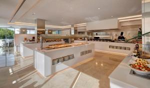a large kitchen with a counter with food on it at Hipotels Bahia Cala Millor - Adults Only in Cala Millor